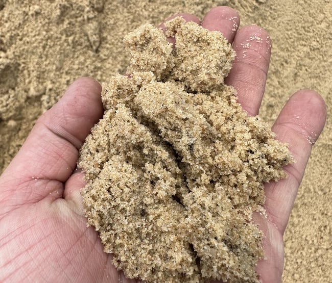 USGA leveling sand in hand